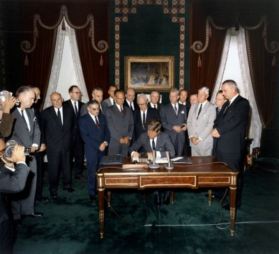 Kennedy signs the Partial Test Ban Treaty, a major milestone in early nuclear disarmament, on October 7, 1963